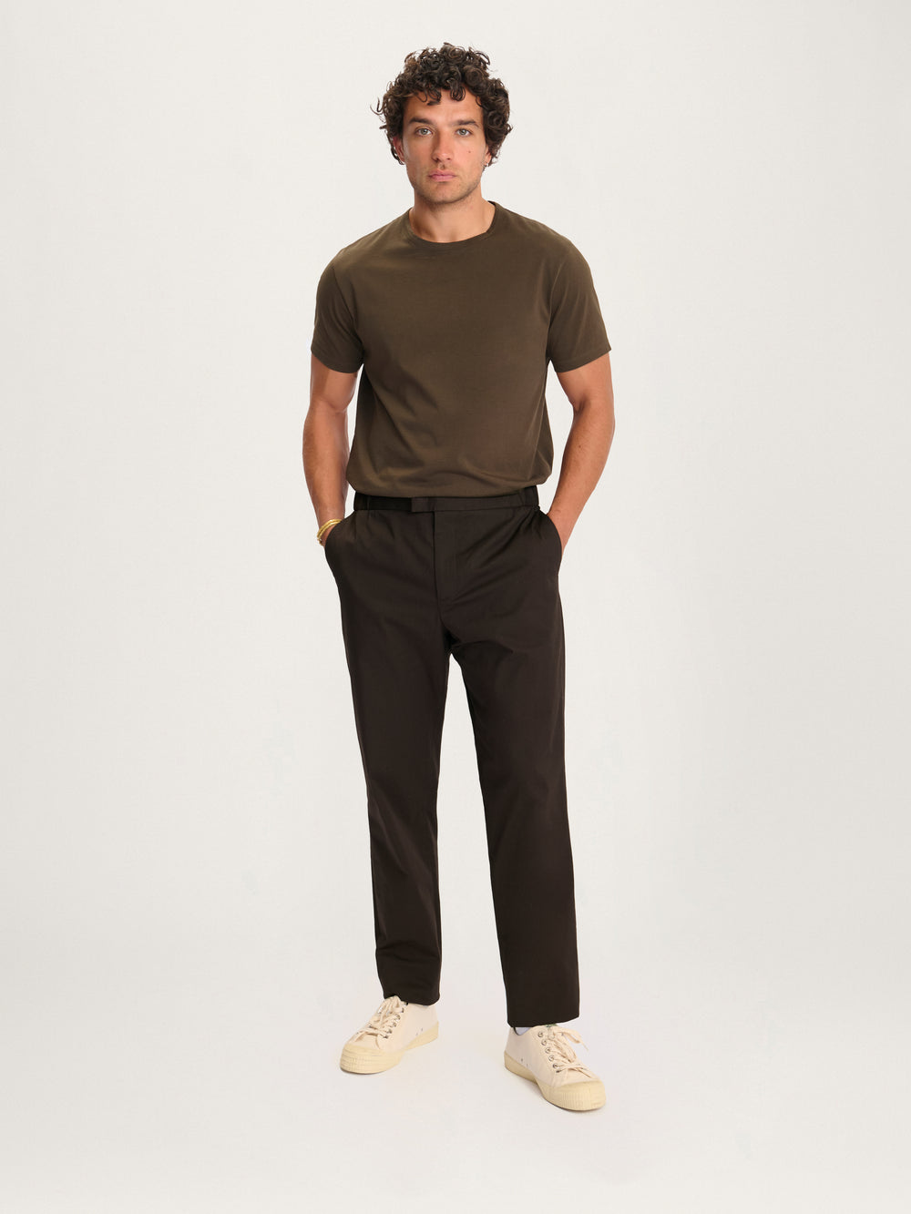 Model wearing Lestrange 24 Trouser Relaxed Espresso – versatile men’s brown pants paired with organic cotton t-shirt.