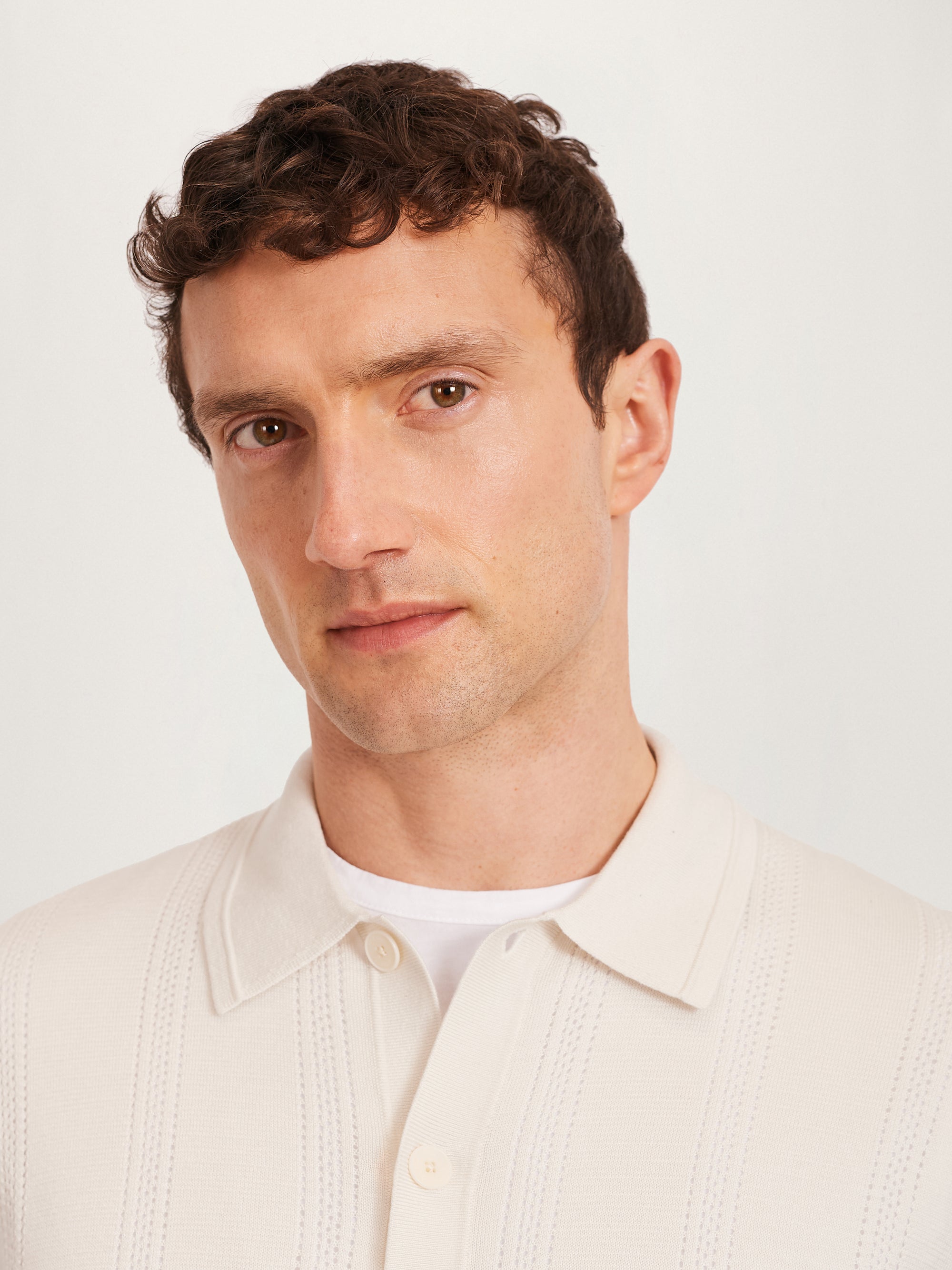 Men’s ecru textured knit shirt with collar and buttons, close-up detail view.
