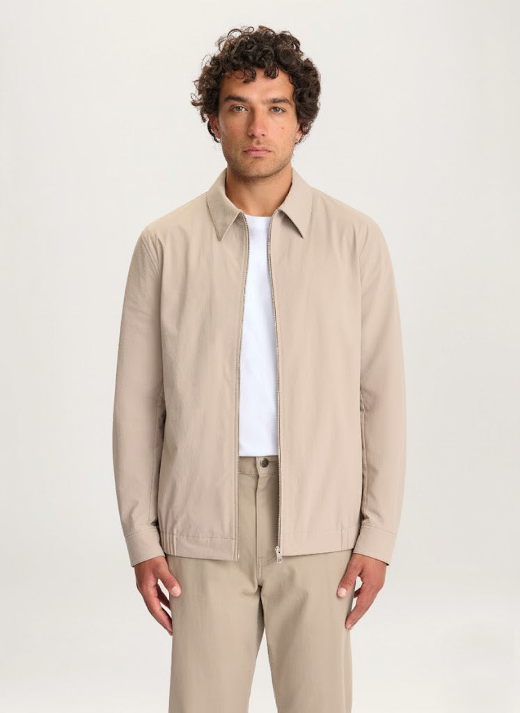 Man wearing the Lestrange London 360 Jacket in beige with a white T-shirt and beige trousers, front view