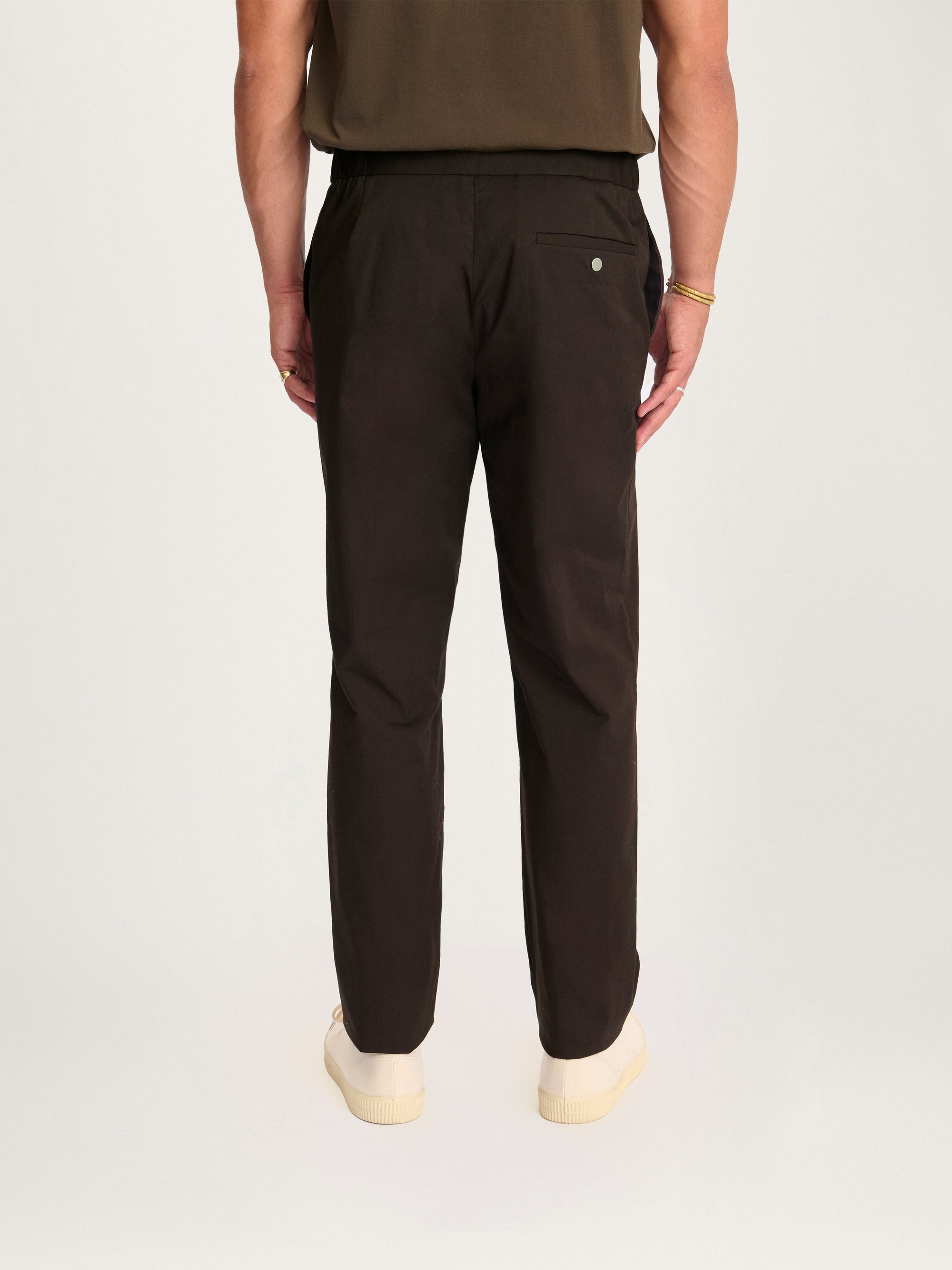 Back view of Lestrange 24 Trouser Relaxed Espresso – men’s tailored sustainable trousers with elastic waistband and sleek silhouette.