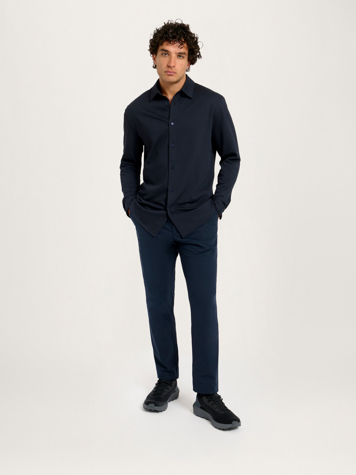 Full-body front view of 183 cm model in Lestrange London 360° Pique Shirt navy, paired with matching trousers and black sneakers