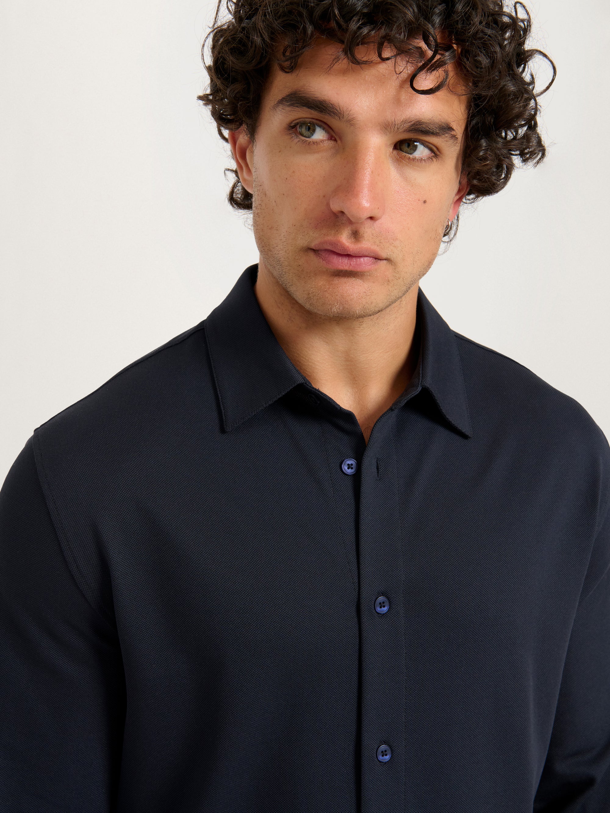 Close-up of model wearing Lestrange London 360 Mesh Tech Shirt in navy, showcasing collar and button detail