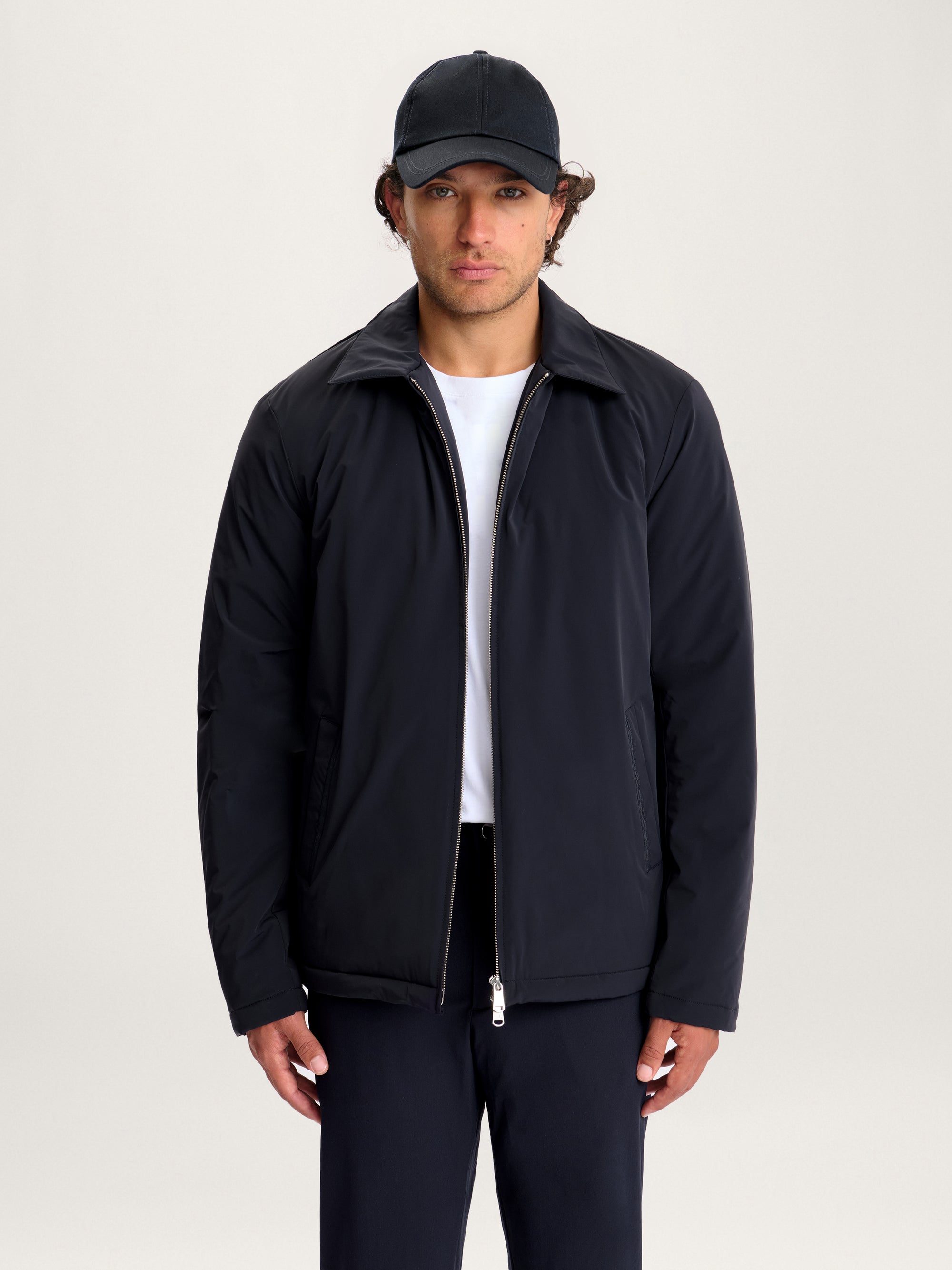 Man wearing Lestrange 360 Thermal Jacket in navy, minimalist insulated jacket with zip closure and pointed collar