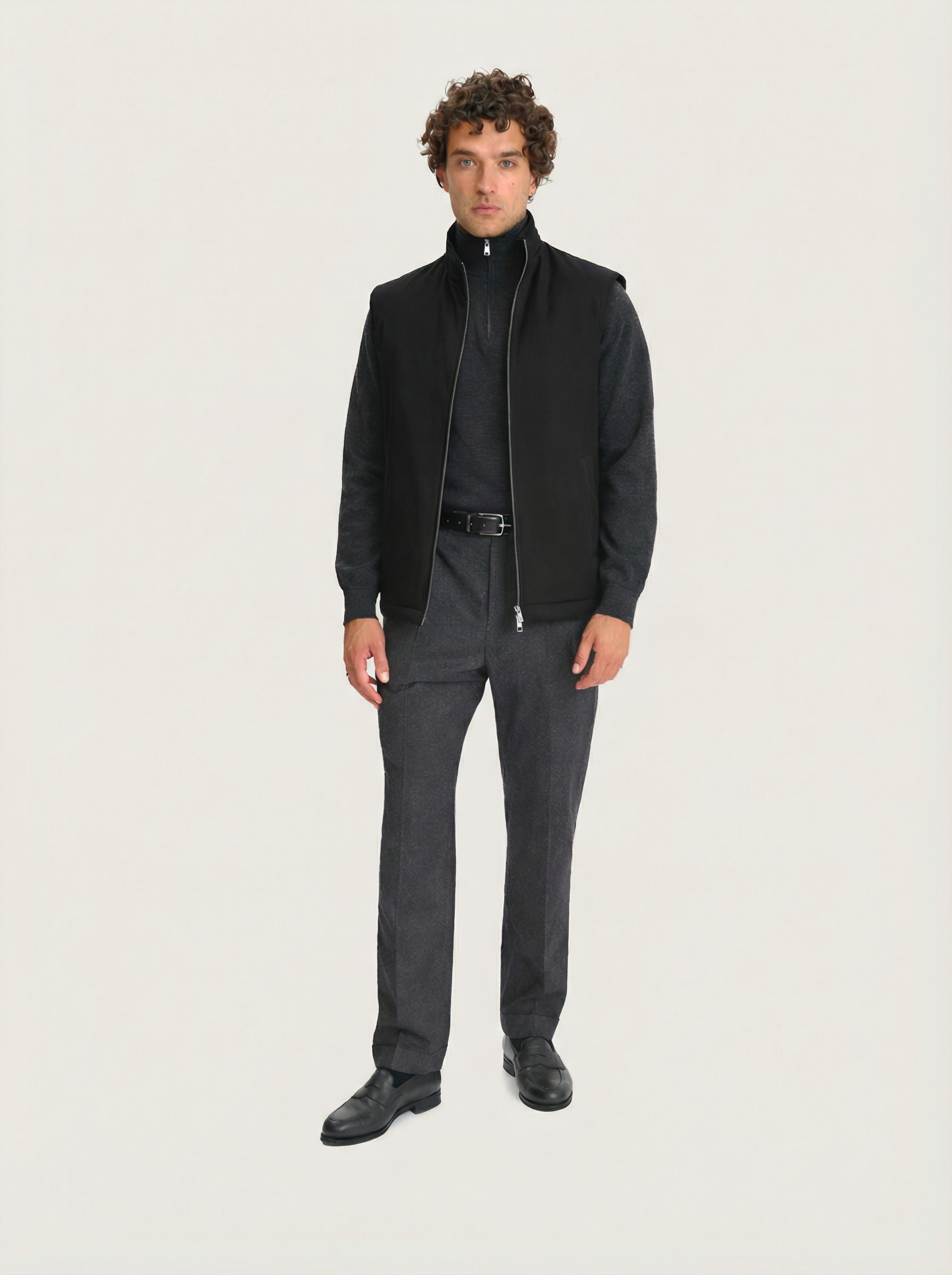 Men’s black Lestrange 360 Thermal Vest, full-length front view, layered with charcoal knit, grey tailored trousers and black leather loafers