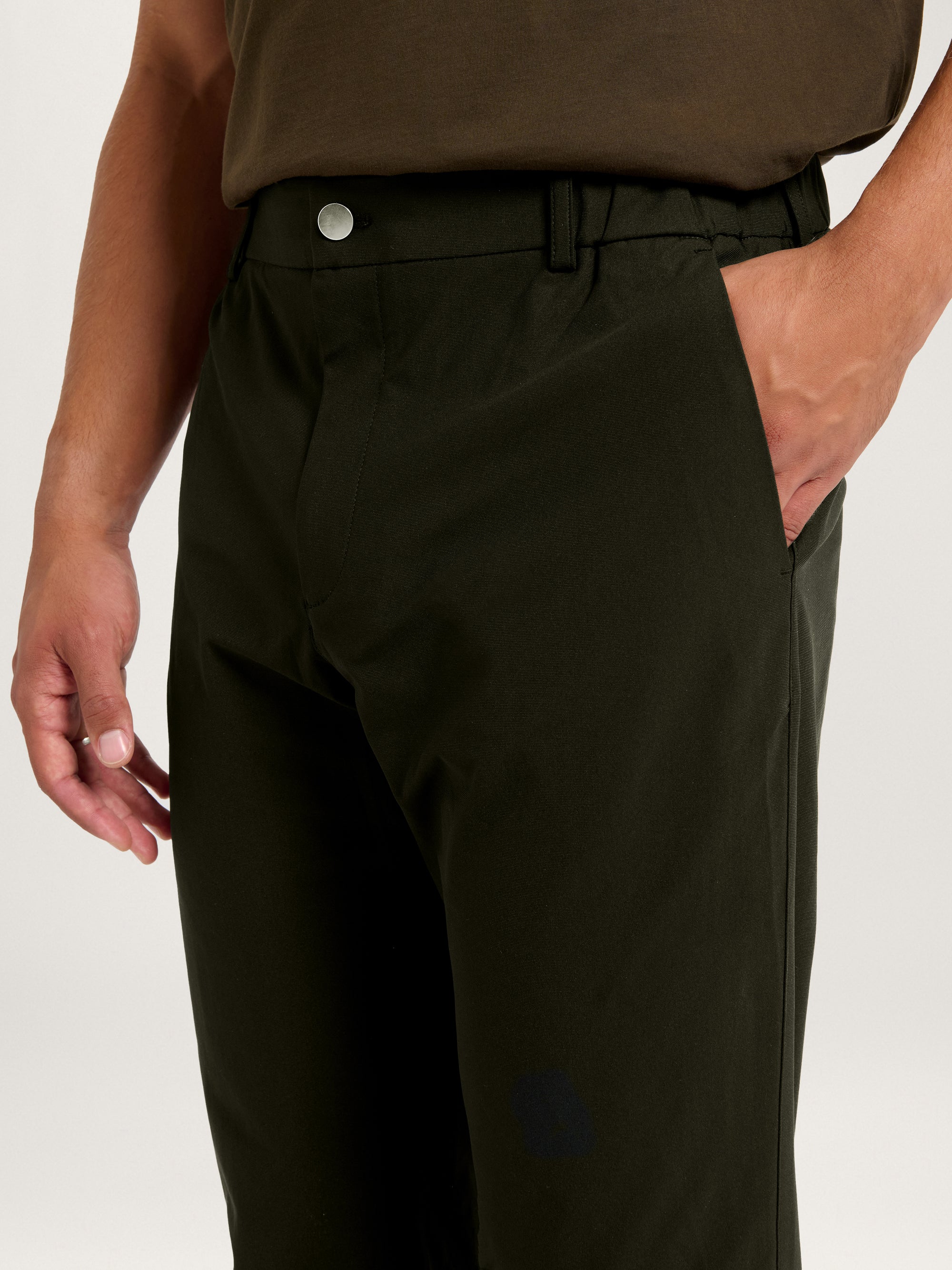 Side-front close-up of the Lestrange 360 Trouser in Dark Olive, highlighting the waistband, pocket, and button.