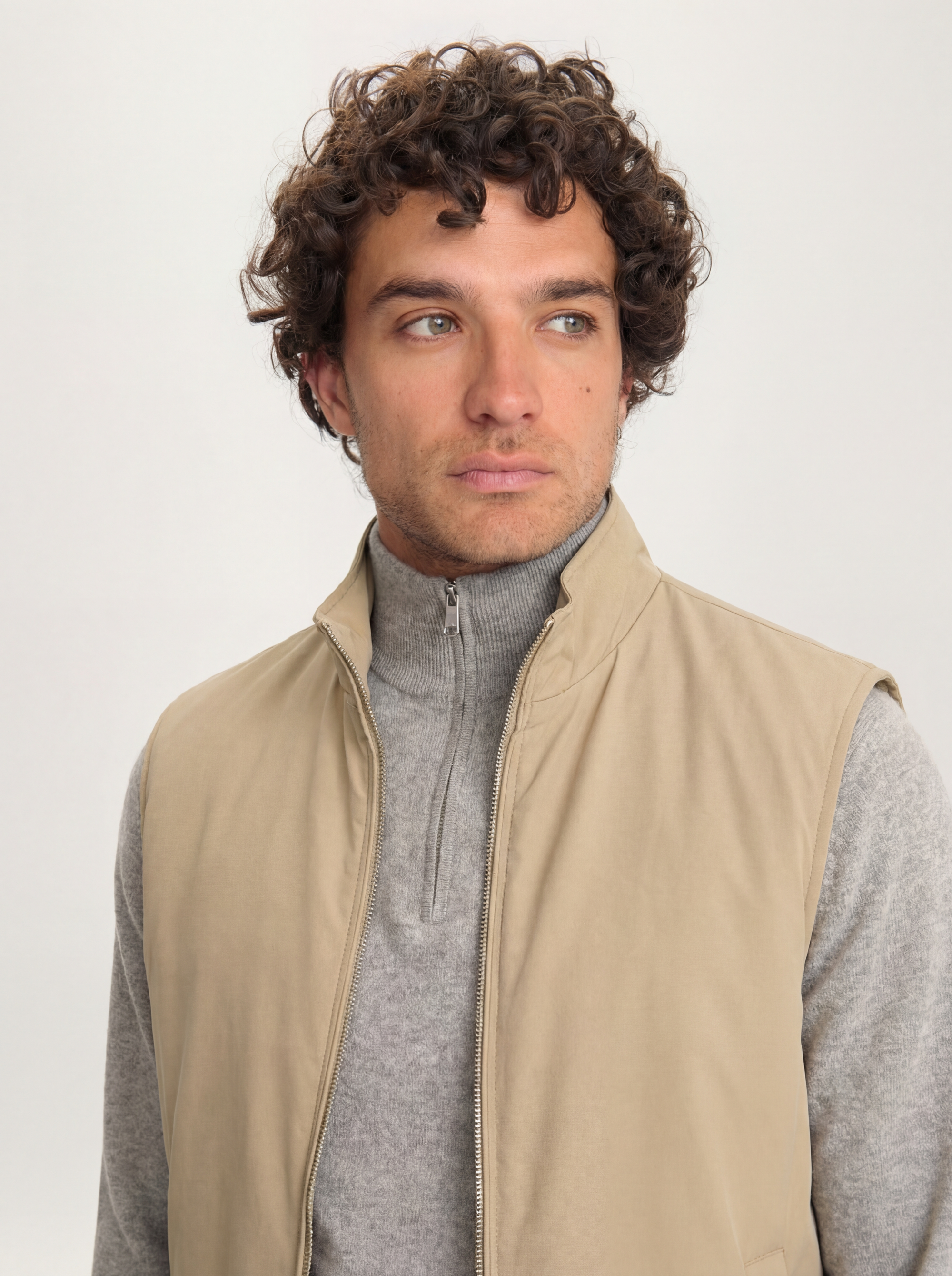 Close-up of Lestrange 360 Thermal Vest in khaki, styled over grey zip-neck knit, premium lightweight sleeveless layer