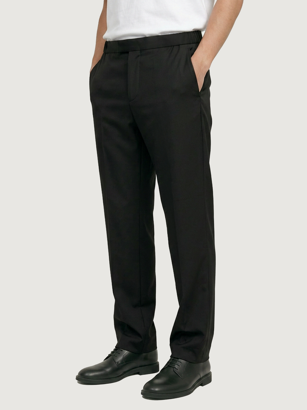 Male model wearing LESTRANGE black tropical wool trousers, showing the relaxed straight-leg fit with side pockets.