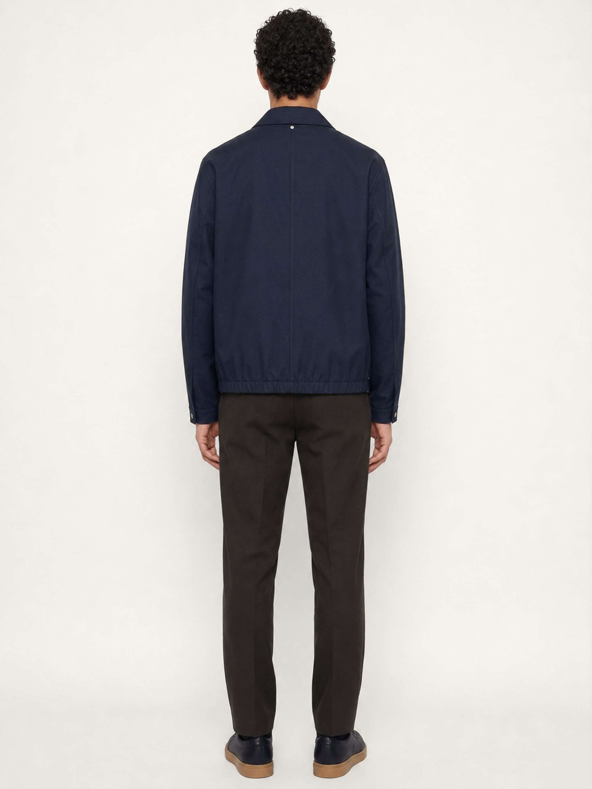 Back view of The 24 Coach Jacket in navy cotton, showing the clean back seam, elasticated hem and relaxed fit.
