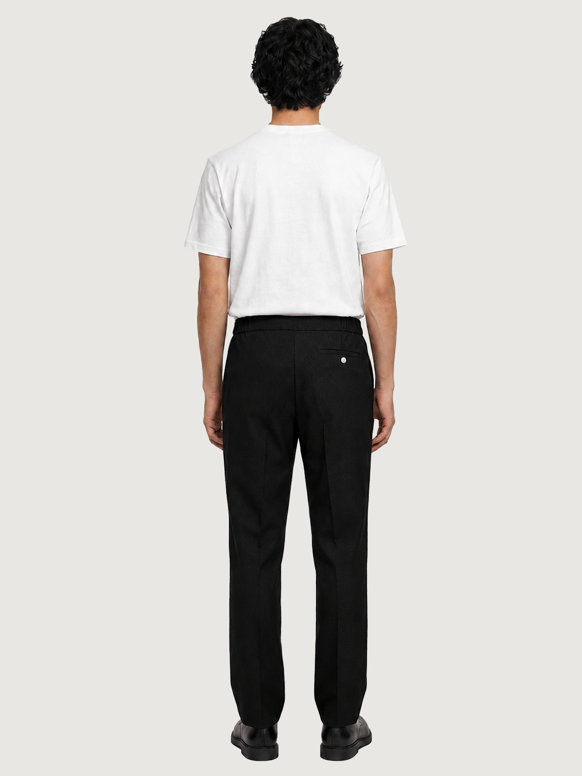 Back view of the LESTRANGE black tropical wool trousers, showing the elasticated waistband and single back pocket.