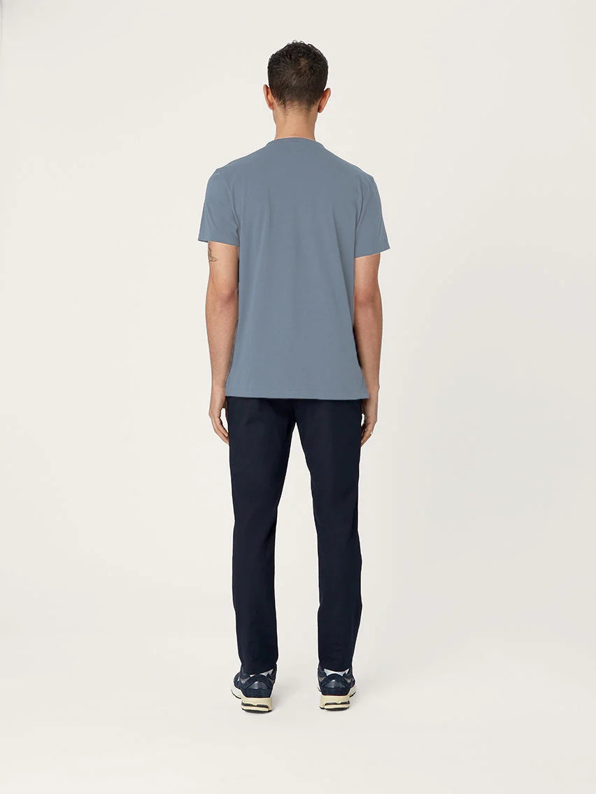 Person wearing a blue t-shirt and dark pants on a white background