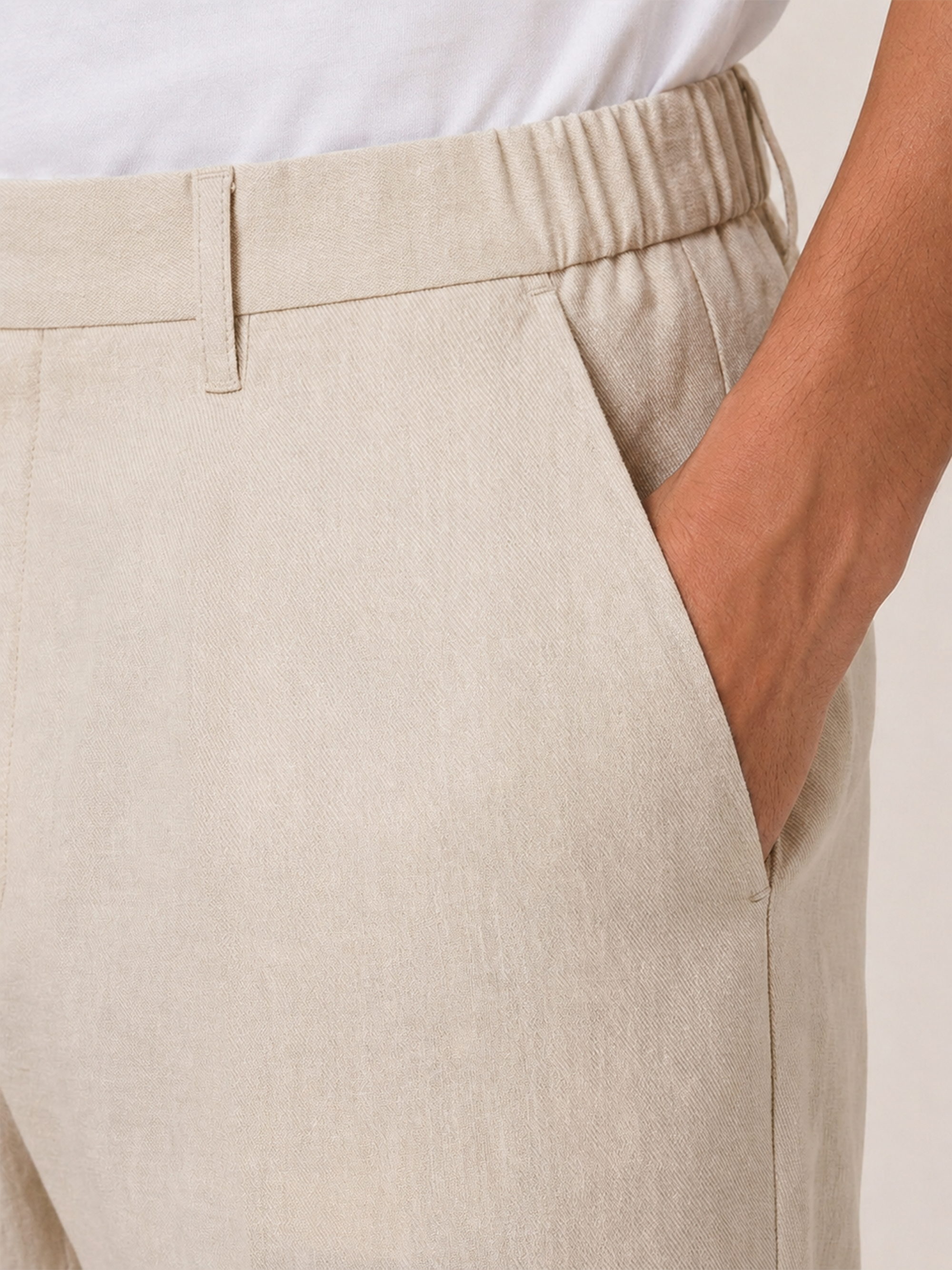 Close-up of the LESTRANGE regular natural beige linen trouser waistband, showing the elasticated side panel, belt loop and textured linen fabric.