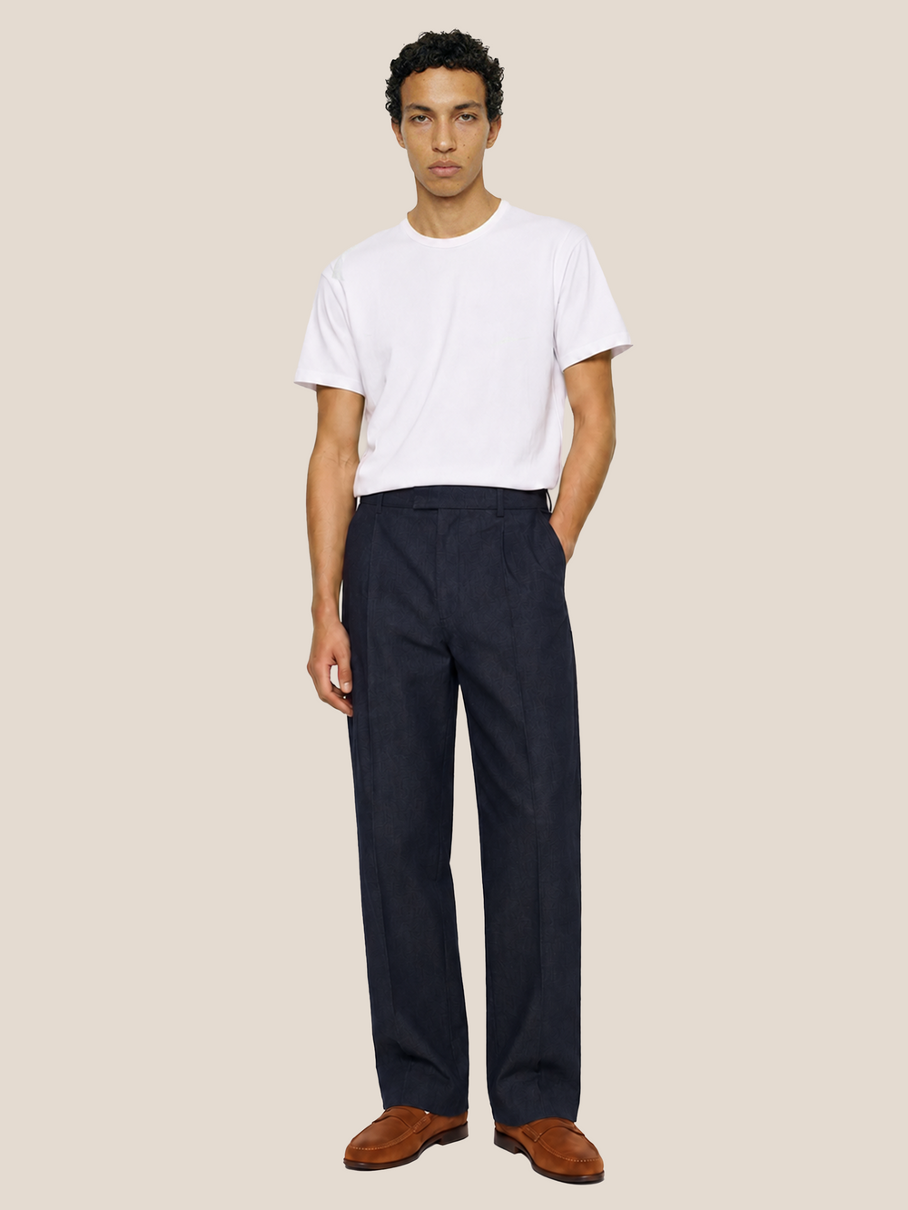 Front view of the LESTRANGE navy linen trousers styled with a white T-shirt and brown leather loafers.