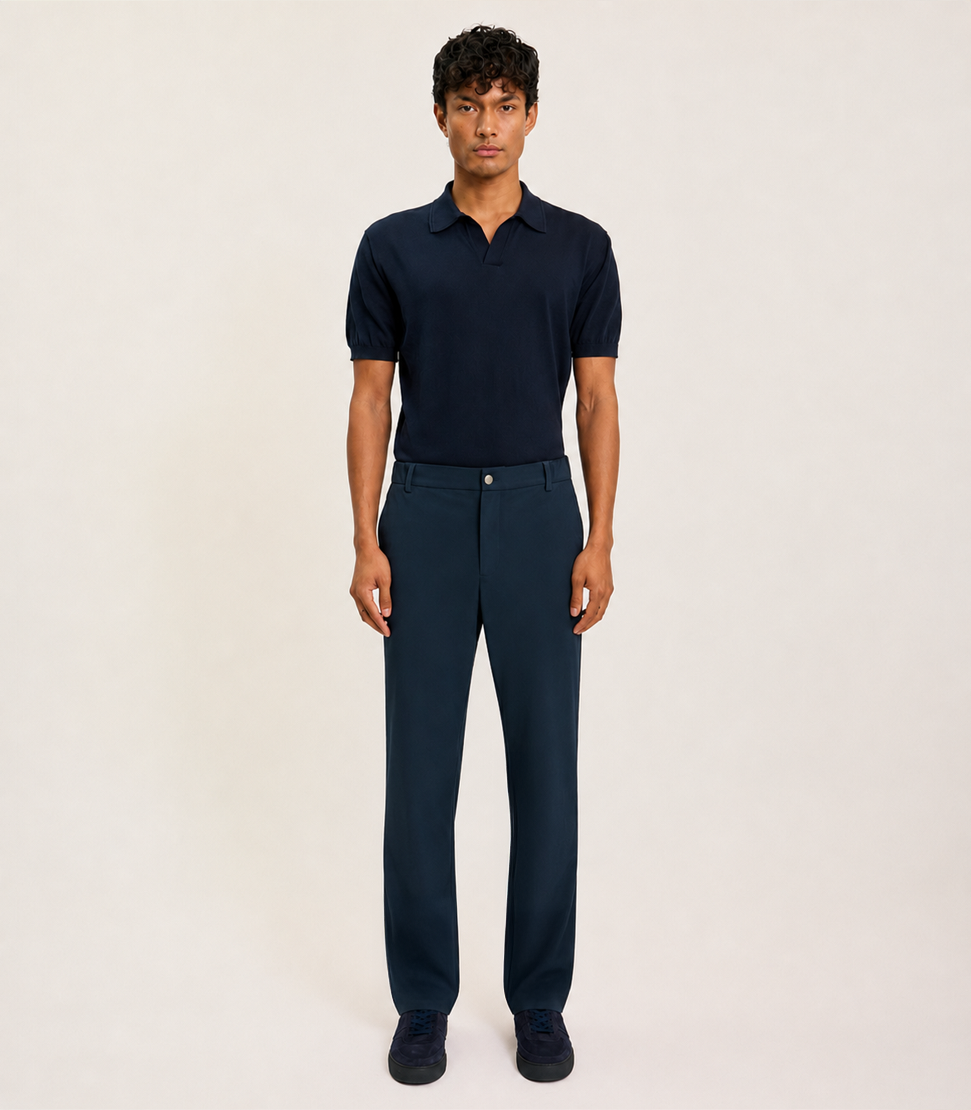 Front view of the LESTRANGE 360 Trouser in navy, styled with a navy polo shirt and matching navy trainers.