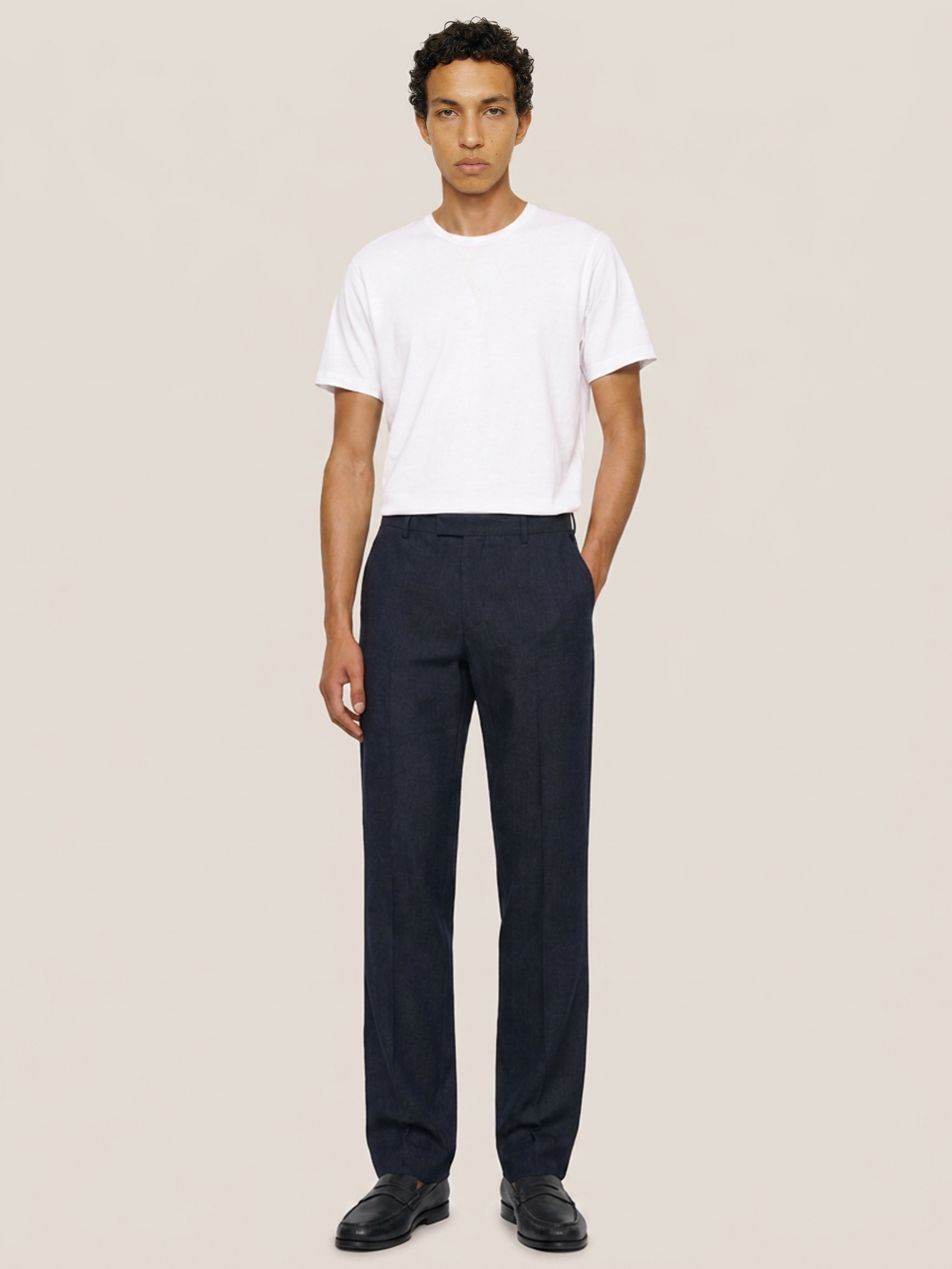 Front view of the LESTRANGE regular navy linen trousers styled with a white T-shirt and black leather loafers.