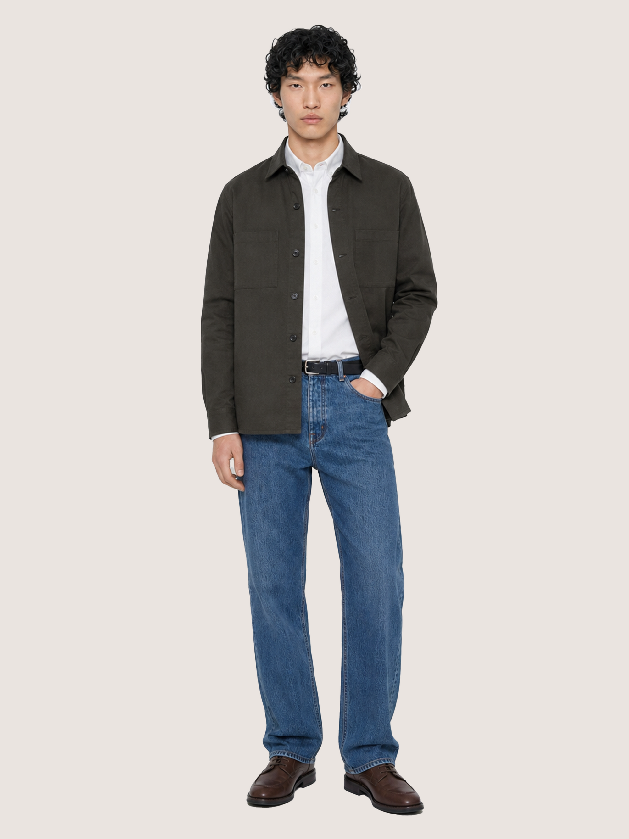 Front view of the LESTRANGE dark olive overshirt styled open over a white shirt with blue denim jeans.