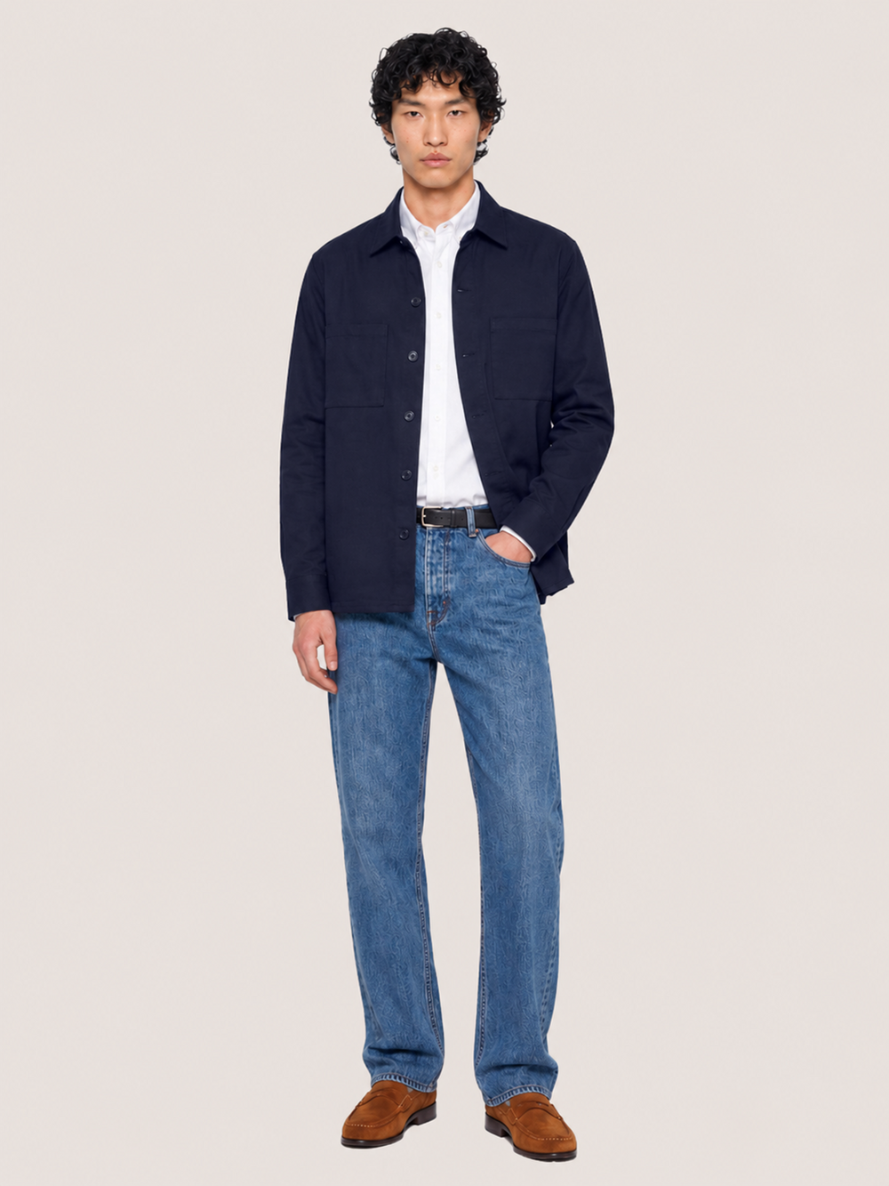 Front view of the LESTRANGE navy overshirt styled open over a white shirt with blue denim jeans.