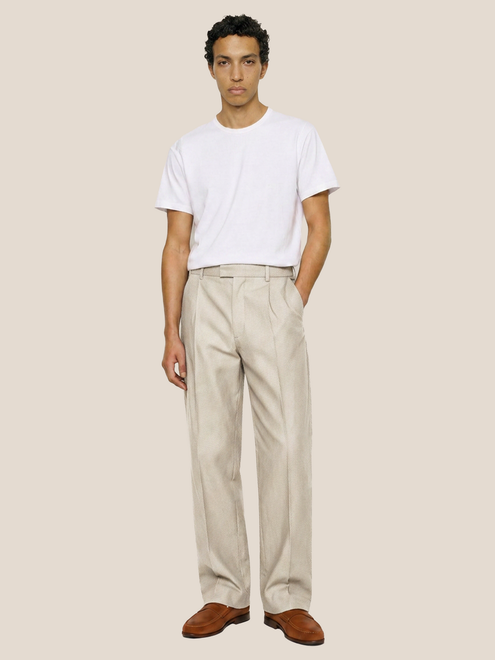 Front view of the LESTRANGE natural beige linen trousers styled with a white T-shirt and brown leather loafers.