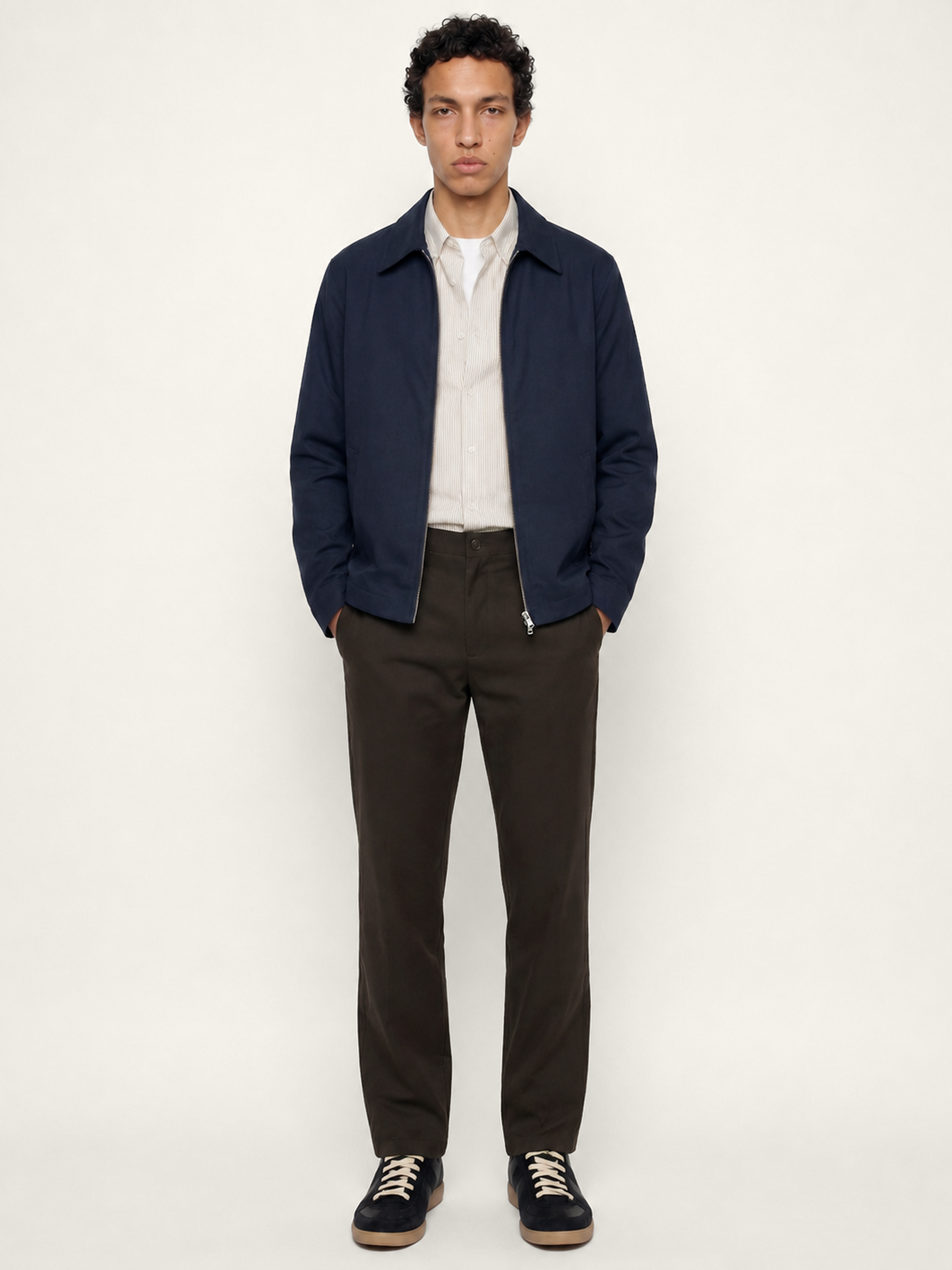 Front view of The 24 Coach Jacket in navy cotton, styled open over a light shirt with dark trousers.