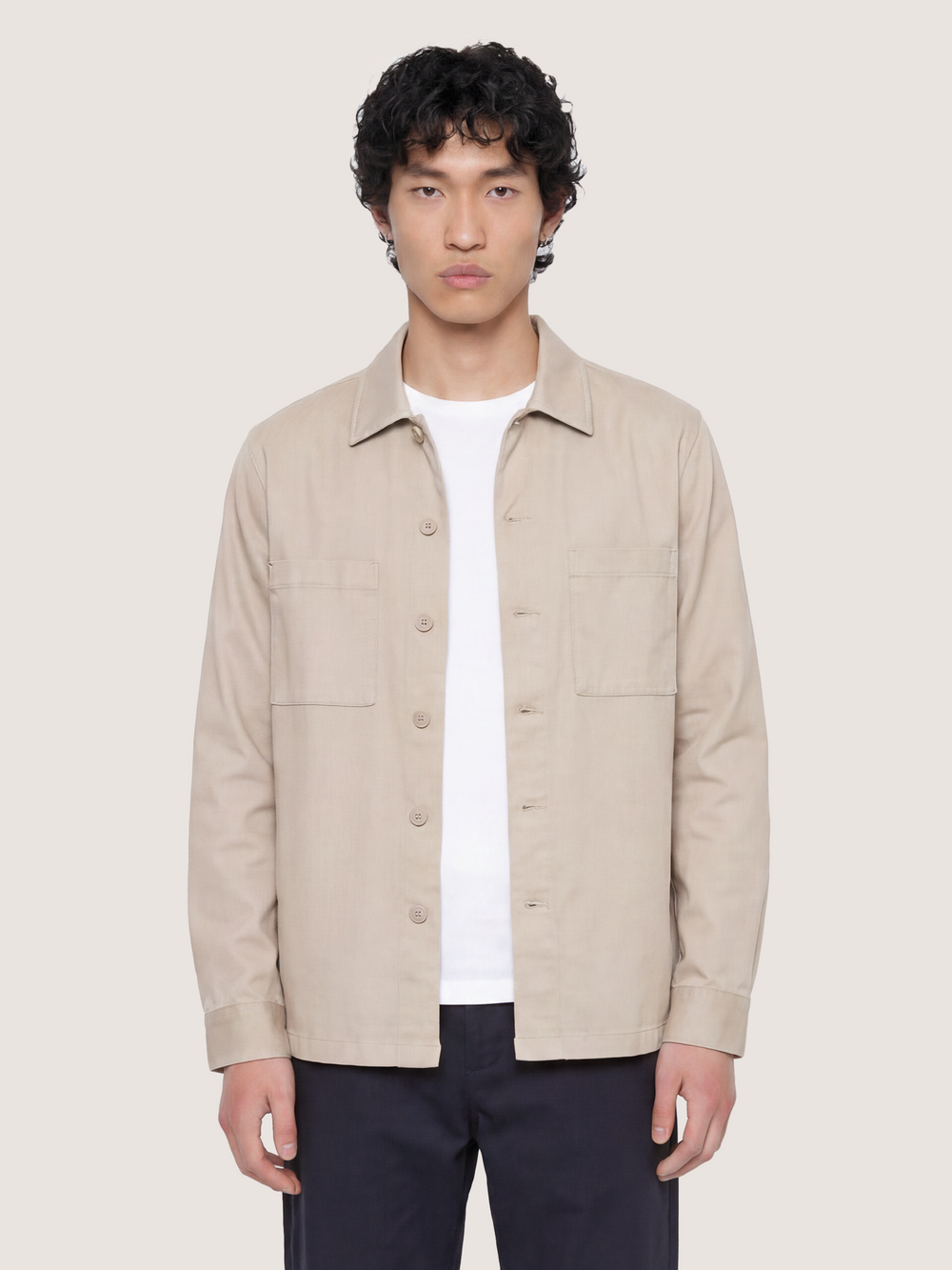 Half-body view of the LESTRANGE beige overshirt, showing the button front, chest pockets and relaxed fit.