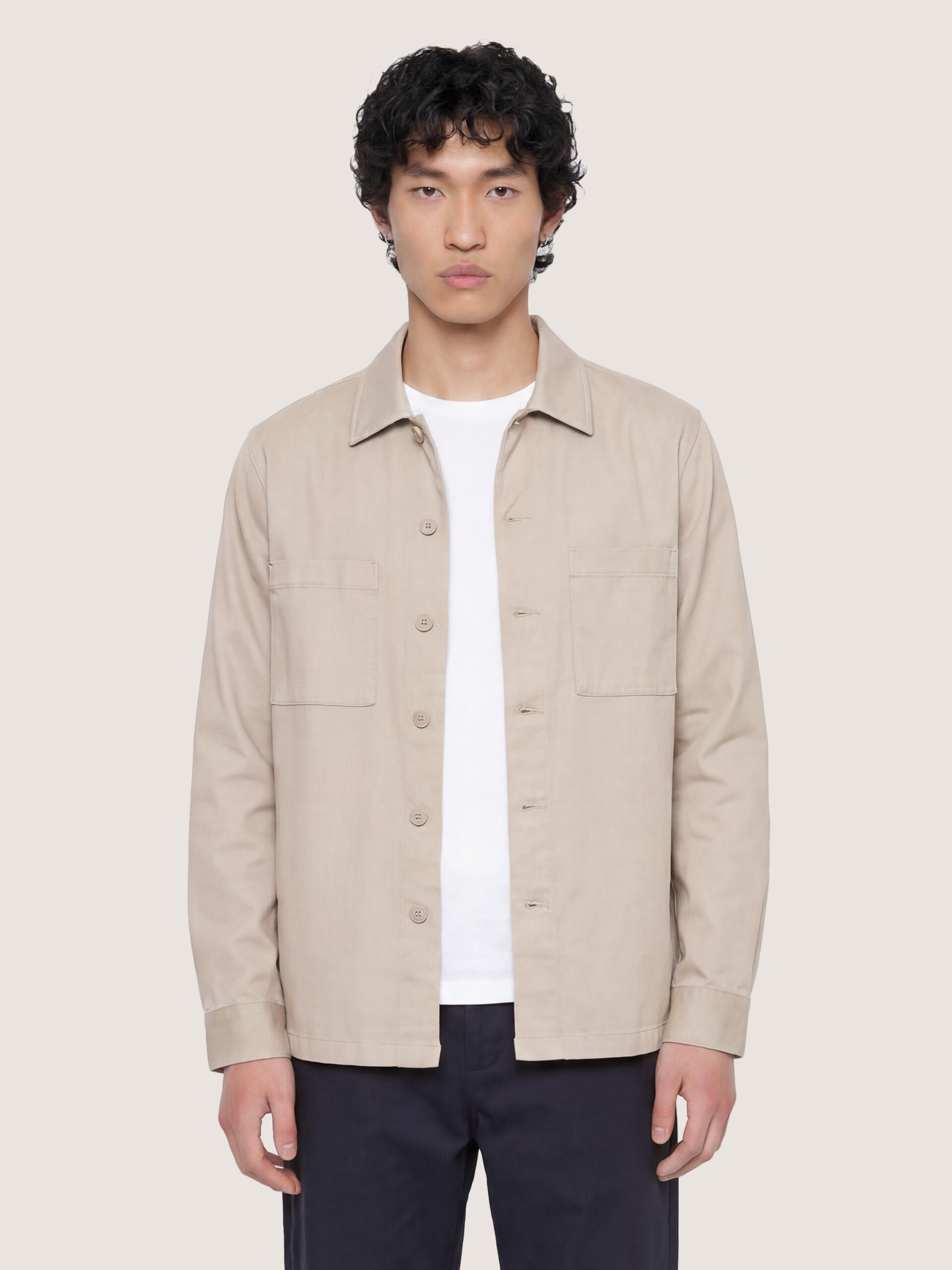 Half-body view of the LESTRANGE beige overshirt, showing the button front, chest pockets and relaxed fit.