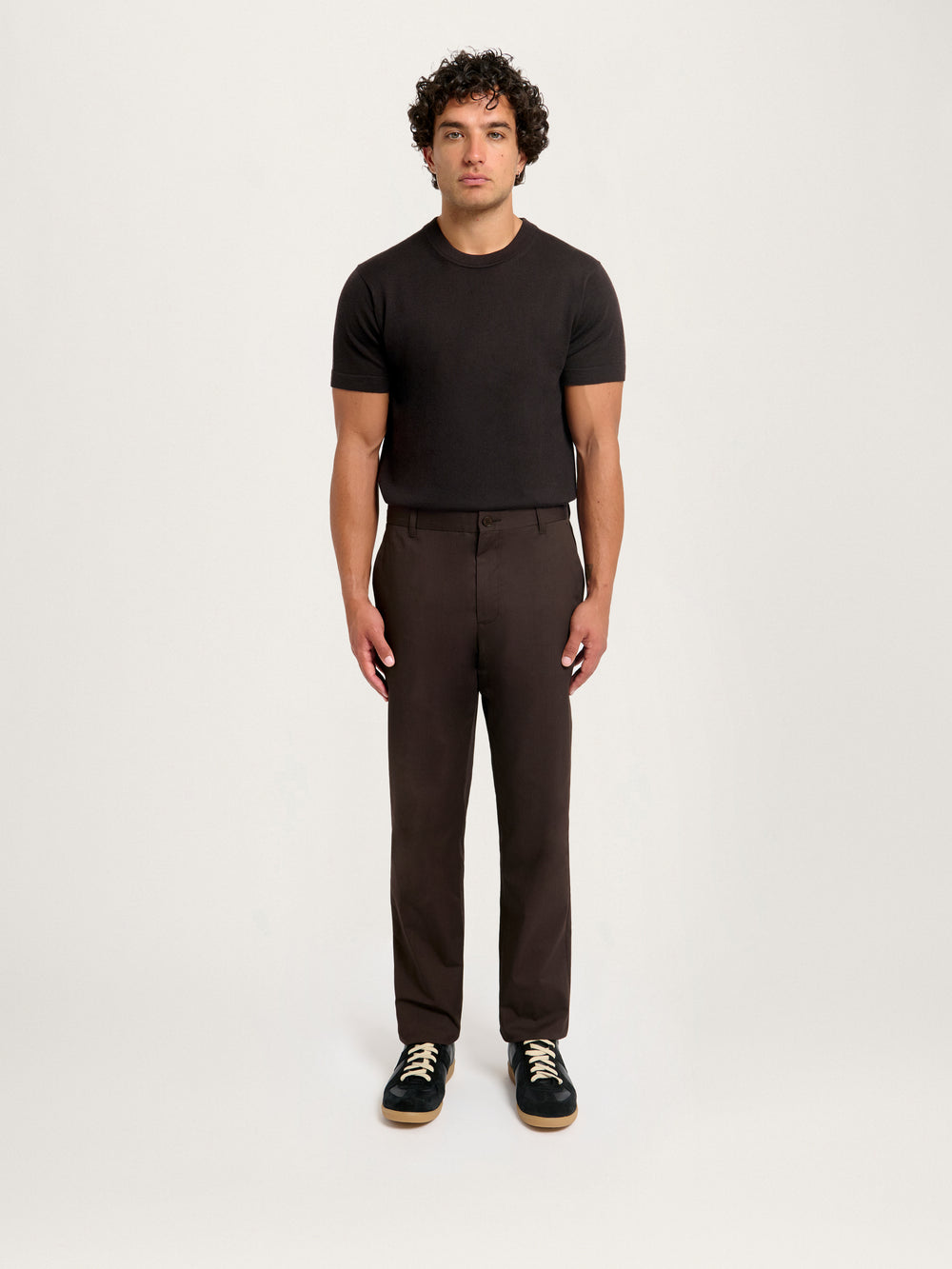 Model wearing Lestrange London Essential Chino in espresso brown, styled with black knit T-shirt and sneakers