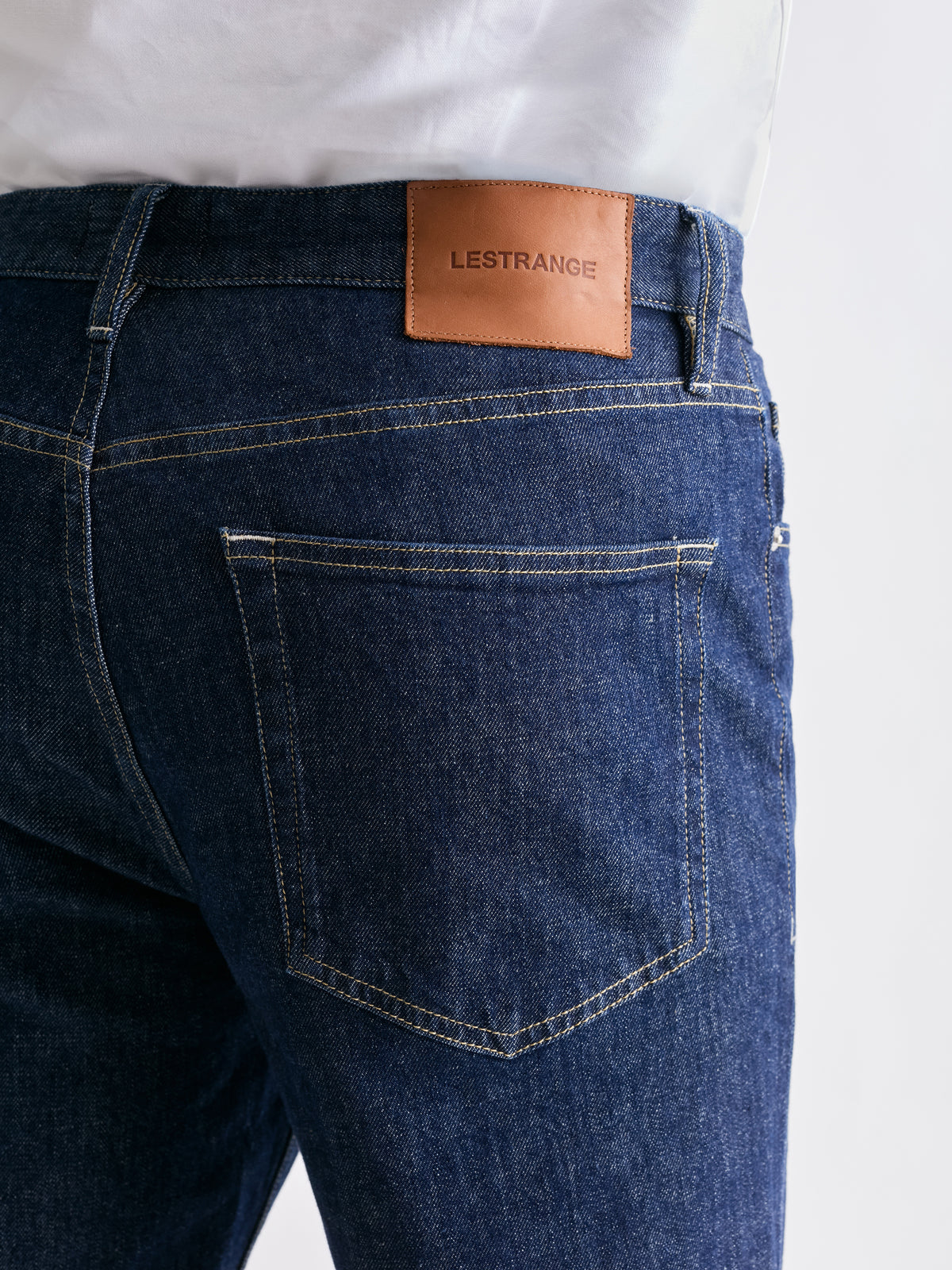 The 24 Jeans Straight Fit in Dark Blue, close-up of back pocket, stitching and LESTRANGE leather patch