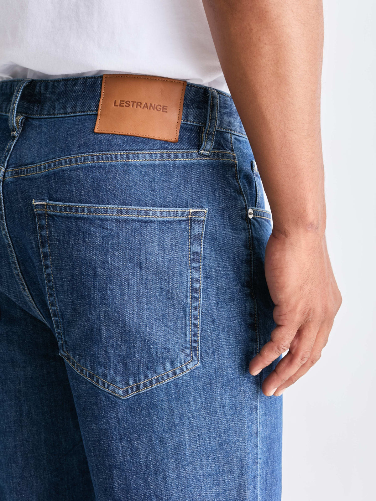 The 24 Jeans Straight Fit in Mid Blue, close-up of back pocket, stitching and LESTRANGE leather patch